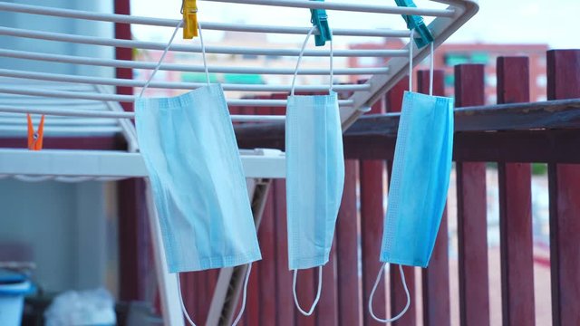 Surgical protection  face mask for coronavirus,   hanging on clothesline string with clothespin. Reuse of these masks can minimize waste,  COVID19 pandemic material