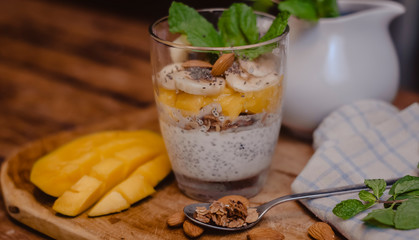 Coconut milk pudding with chia seeds and mango on a wooden background