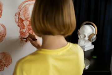 Attractive Woman drawing skull with headphones