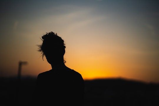 silueta de mujer al atardecer de colores naranja y azul
