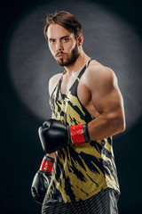 Fototapeta na wymiar A man in Boxing gloves. A man Boxing on a black background. The concept of a healthy lifestyle