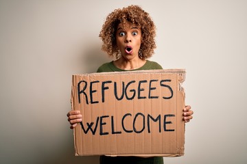 African american woman asking for immigration holding banner with wlecome refugees message scared...