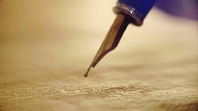 close-up, old ink pen, writes on papyrus words and letters