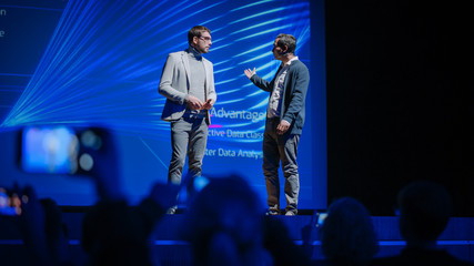 Stage: Startup CEO and Hardware Engineer Present New Product. Speakers Lead Lecture on Business, Science, Technology, Entrepreneurship, Health, Ecology, Development, Leadership and all Things Digital