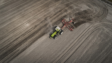 Farmers cultivating. Tractor makes vertical tillage. Aerial view