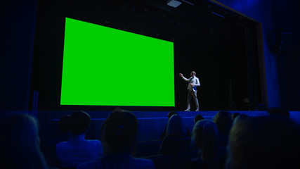 Keynote Speaker Announces New Product to the Audience, Behind Him Movie Theater with Green Screen,...