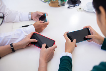 Group of business ands searching for data on mobile phone with analyzing charts at his workplace.concept