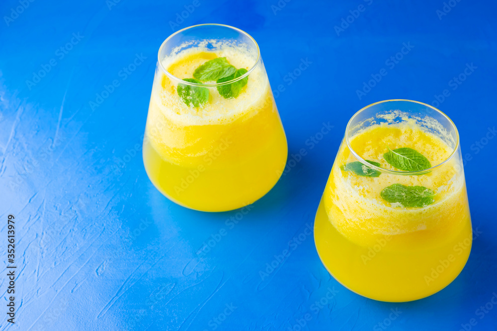 Wall mural pineapple juice on a blue background. juice for detox in the glass. pineapple smoothie with fresh pi