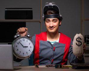 Young handsome repairman repairing computer