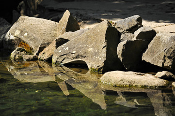 Large stones with reflection in water in summer day in Crimea