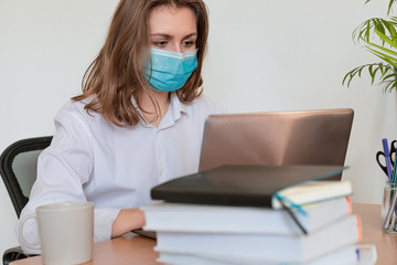 Woman in quarantine for Coronavirus wearing protective mask and smart working