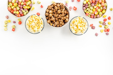 Colorful popcorn in bowl on white background top view copy space