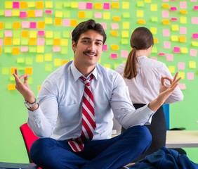 Man and woman in the office with many conflicting priorities in