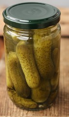 Delicious cornichons in a jar on the table 