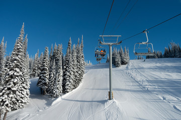 Tourists in ski lift over ski resort, Sun Peaks Resort, Sun Peaks, British Columbia, Canada