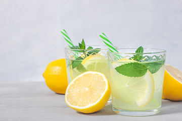 Lemon lemonade with herb on grey background.