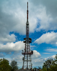 Transmission tower on the top of the mountain with beautiful clouds and blue sky in the background.