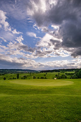 Obraz premium spring looking grassland, small gold course and flowers with sunrays in the sunrise