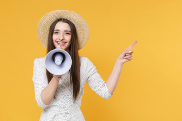 Smiling young brunette woman girl in white dress hat posing isolated on yellow wall background studio. People lifestyle concept. Mock up copy space. Scream in megaphone pointing index finger aside up.