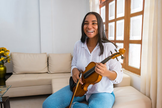 Portrait Of A Teenage Female Musician At Home With A Violin