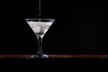 Martini with an olive on a black background
