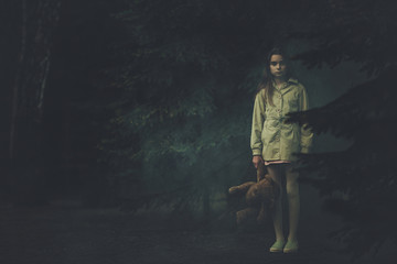 Lost Emotionless Girl with Teddy Bear in the Middle of Dark Night Forest