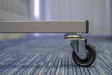 Small black rubber wheel on the carpet.Office abstract background