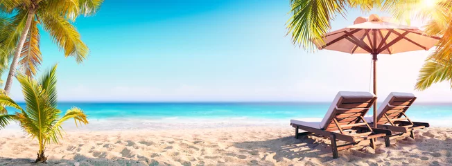  Ligstoelen en parasol met palmbomen op het tropische strand © Romolo Tavani