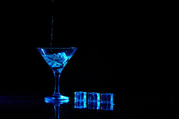 Martini cocktail drink splash with ice cubes in neon iridescent . Minimal night party life concept.