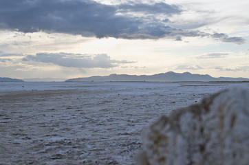 The salty landscape and old salty post out on the great salt lake in the dusk sunlight. 