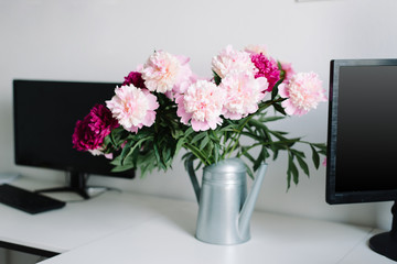 peonies in a garden watering can, a desktop in the home