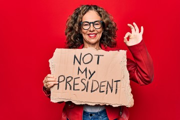 Middle age woman asking for democracy holding banner with not my president message doing ok sign...