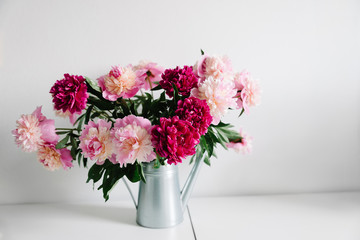 pink flowers. Curly peony ranunculus in Metallic gray watering can,empty space