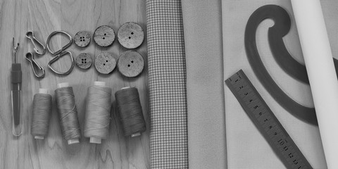 sewing threads, fabric, tracing paper roll, patterns and other sewing accessories prepared for cutting and sewing clothes