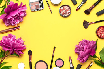Professional makeup brushes, powder, eyeshadow, blush, lipstick cream on yellow background flat lay top view copy space. Beauty product women's accessory fashion. Different brushes Cosmetic makeup Set