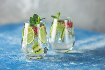 Detox water or martini tonic cocktail with kiwi, lime and ice, decoration pomegranate and mint....