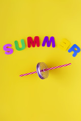Colored letters forming the word summer with a red straw between them