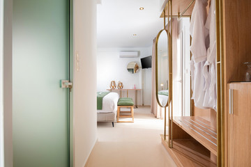 Fototapeta na wymiar Apartment entrance hallway with bathroom glass door and wooden wardrobe cabinet. front view of modern spa hotel interior room