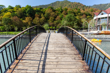 Fototapeta na wymiar Humpback wooden bridge over the river