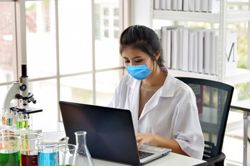 Female Doctor with protective mask working at her office.