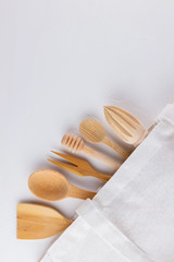 Zero waste concept. Cotton bag and and wooden cutlery on a white background. Eco friendly wooden cutlery and eco bag. Plastic free concept. Minimalism. Copy space