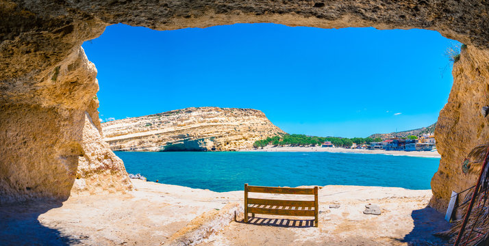 Matala beach with caves on the rocks that were used as a roman cemetery and at the decade of 70's were living hippies from all over the world, Crete, Greece - Powered by Adobe