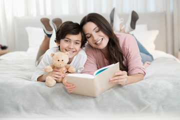 Woman reading a book for her son