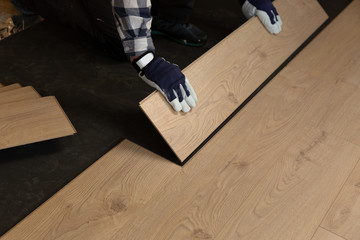 Fototapeta premium Construction worker installing laminate floor in a new renovated attic. Home improvement concept.