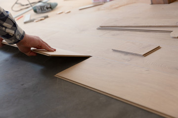 Construction worker installing laminate floor in a new renovated attic. Home improvement concept.