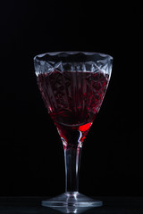 Red wine in a crystal glass. Photo on a black background