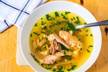 Turkey soup with with large pieces of meat in white plate,closeup.