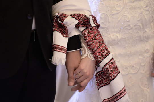 Hands tied with ribbon at traditional handfasting wedding ceremony