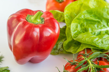 big red pepper near various vegetables. vegan food.