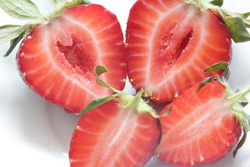 Fresh red strawberry cut in half on a white background. Healthy food